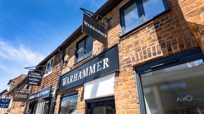 Hanging shop signs including Warhammer above the shopfronts on Milkhouse Gate